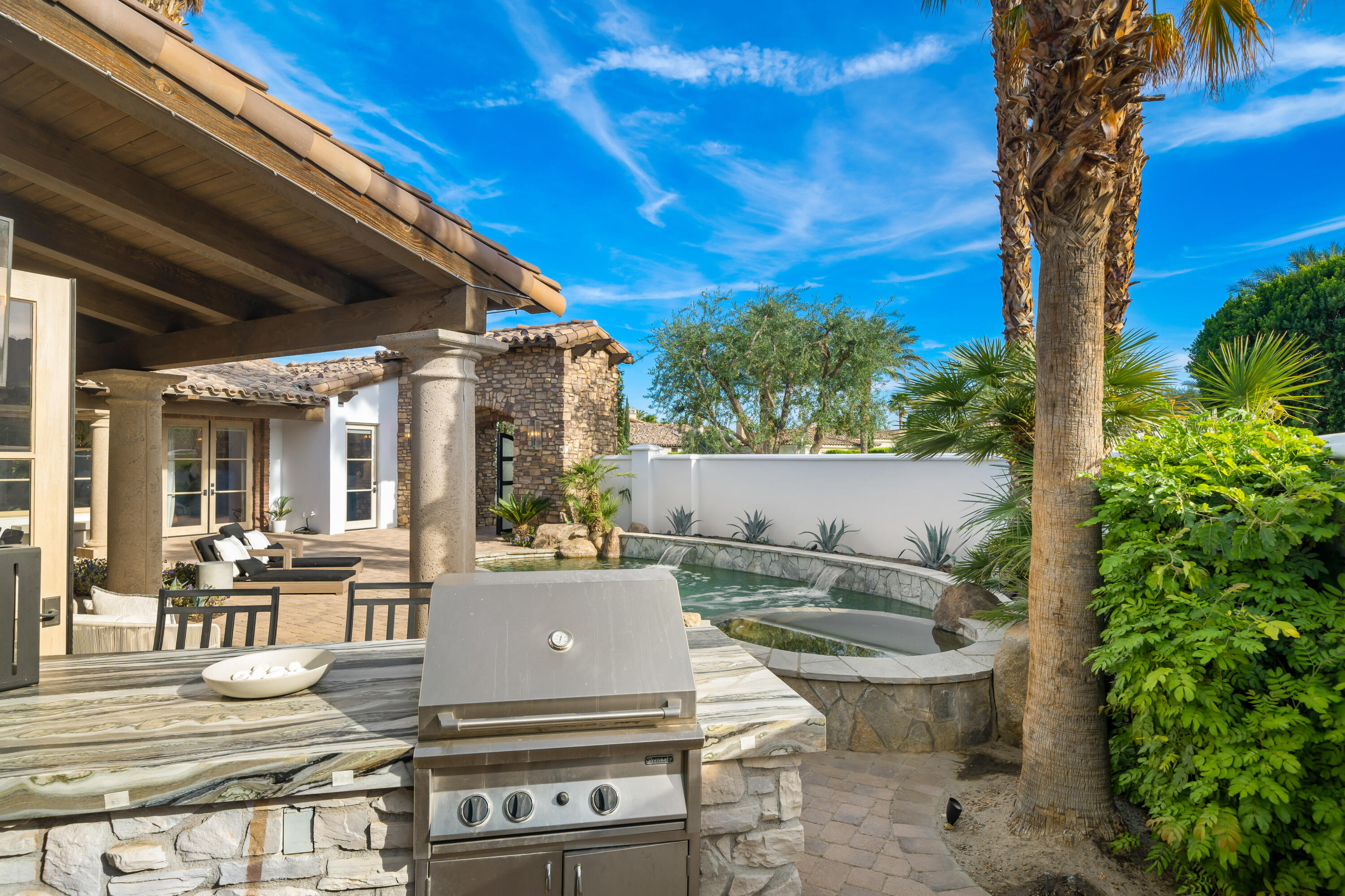 80820 Via Portofino La Quinta, CA 92253 - Photo 43 of 52 a view of a patio with table and chairs potted plants and palm tree