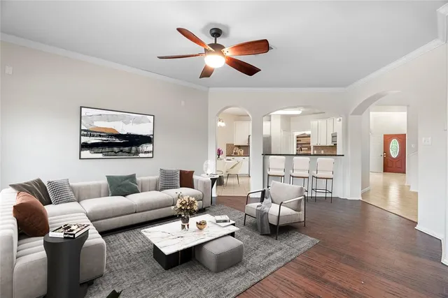a living room with furniture ceiling fan and a wooden floor