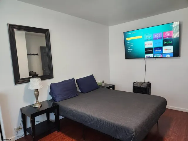 a bedroom with a bed and a flat screen tv