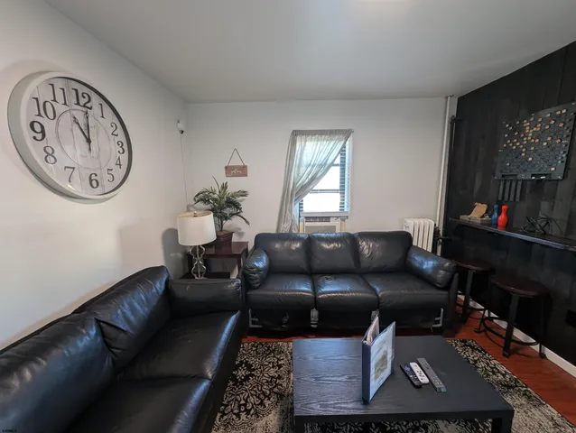 a living room with furniture a flat screen tv and a wall painting