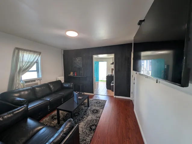 a living room with furniture and a wooden floor