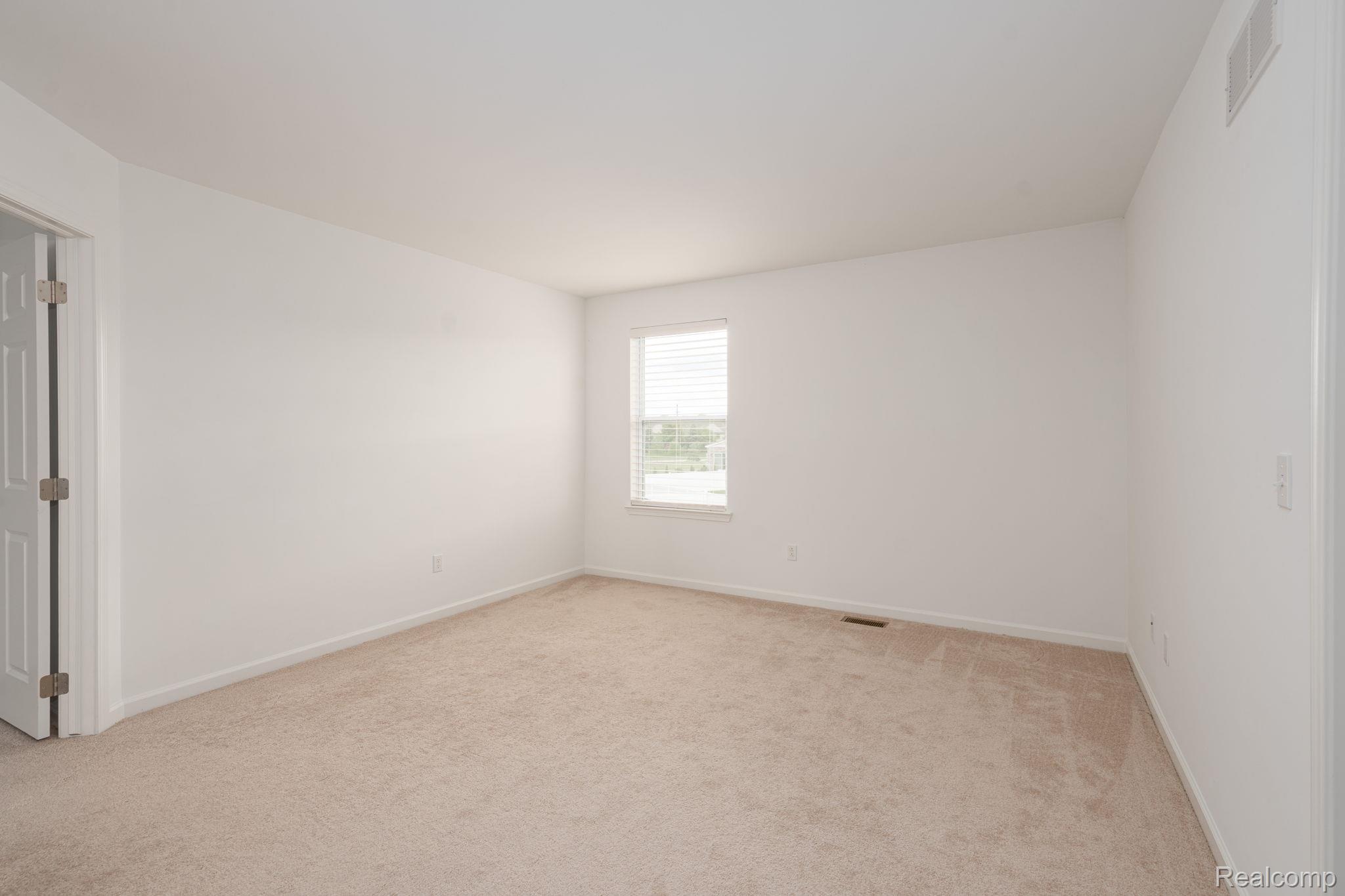 48904 Carnegie Way Macomb, MI 48042 - Photo 19 of 34 Spacious room featuring neutral carpet flooring, white walls, and a window with horizontal blinds