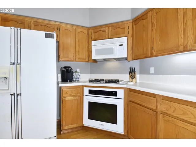 a kitchen with stainless steel appliances granite countertop a sink a stove and a refrigerator