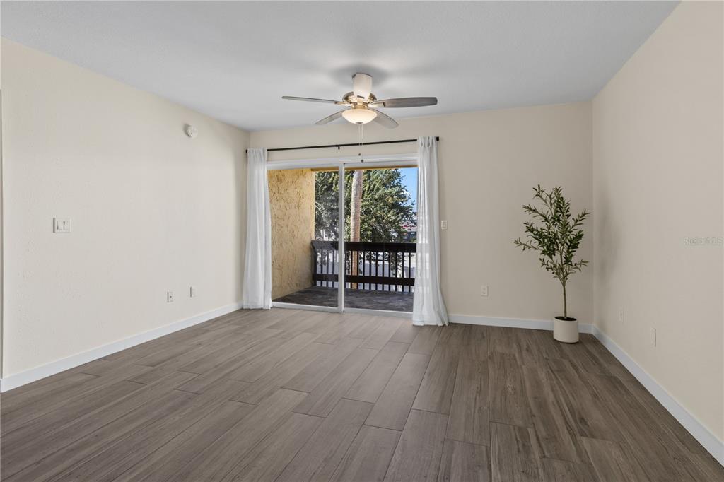 3405 Clark Road, Unit 205 Sarasota, FL 34231 - Photo 9 of 28 a view of an empty room with a window and wooden floor
