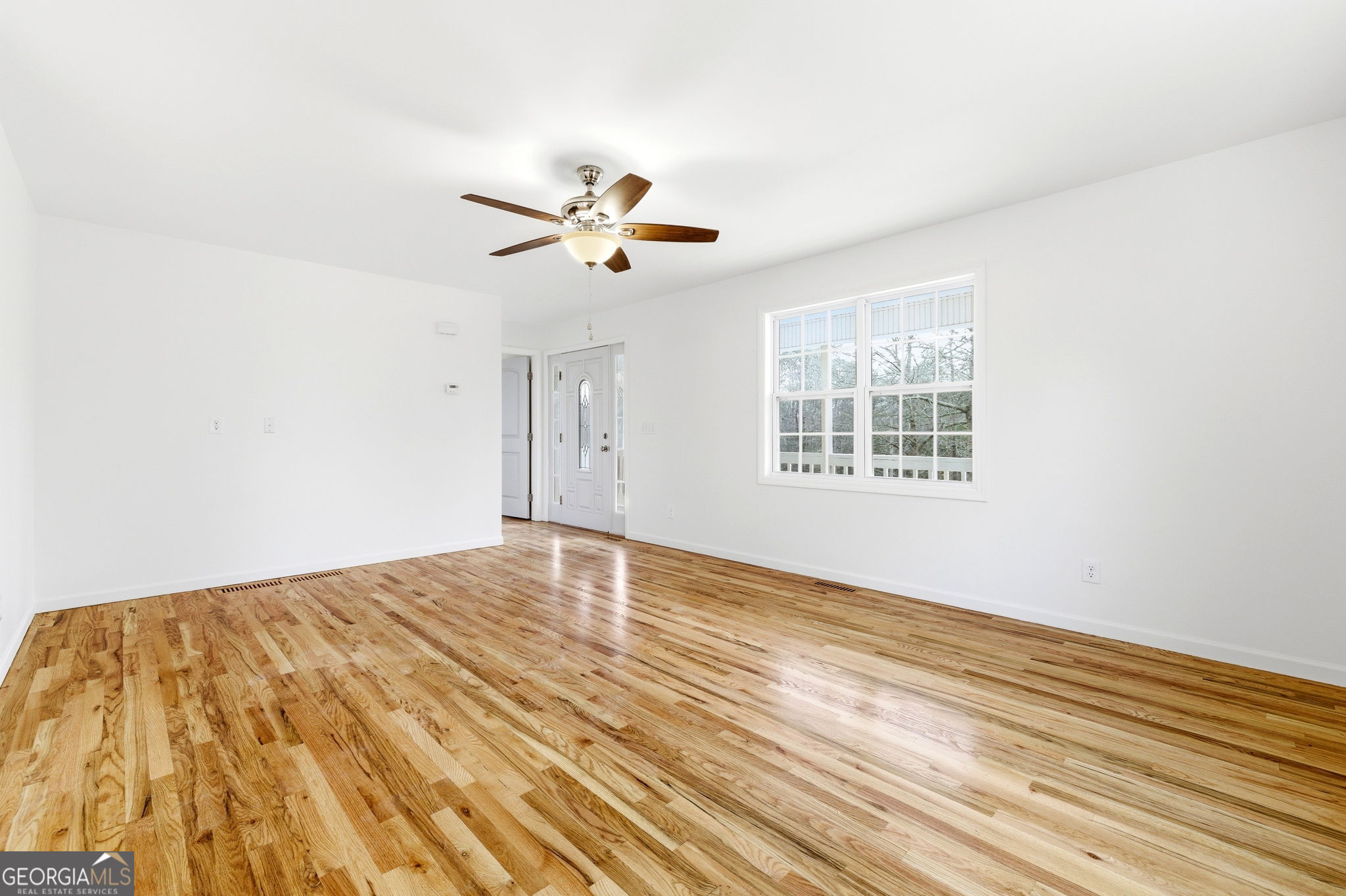 1429 Crumps Bridge Road Martin, GA 30557 - Photo 16 of 54 wooden floor in an empty room with a window