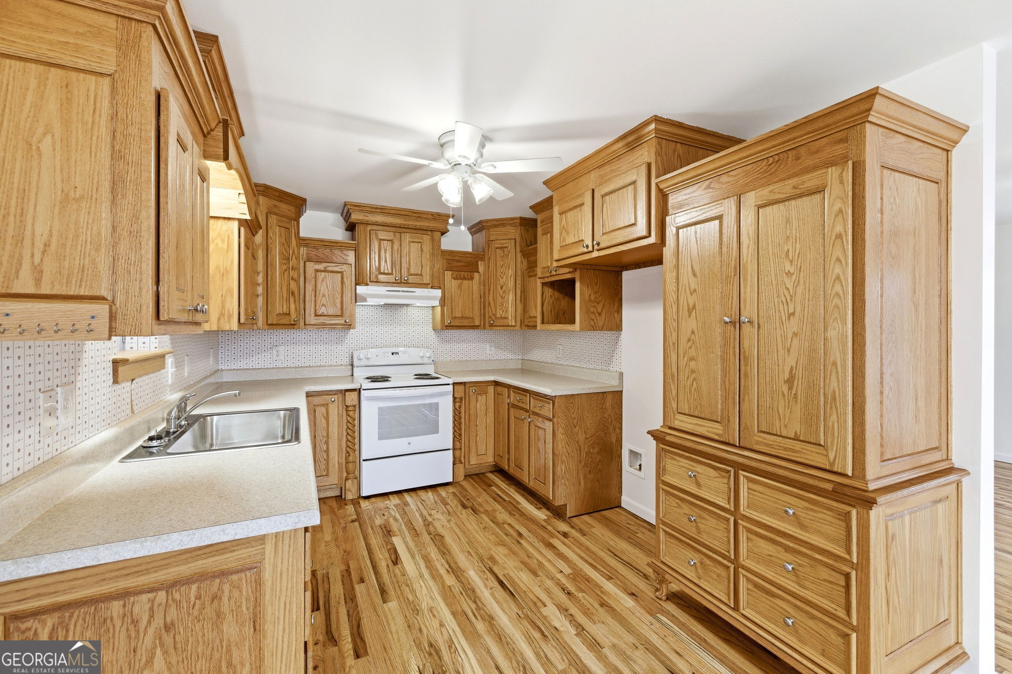 1429 Crumps Bridge Road Martin, GA 30557 - Photo 3 of 54 a kitchen with stainless steel appliances granite countertop a refrigerator a sink dishwasher a stove and white countertops with wooden floor