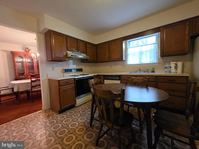 a kitchen with stainless steel appliances granite countertop a sink a stove a table and chairs