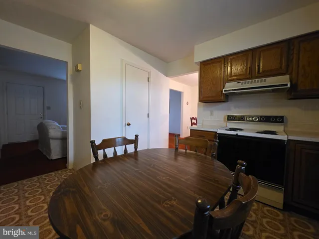 a kitchen with a table chairs and a refrigerator