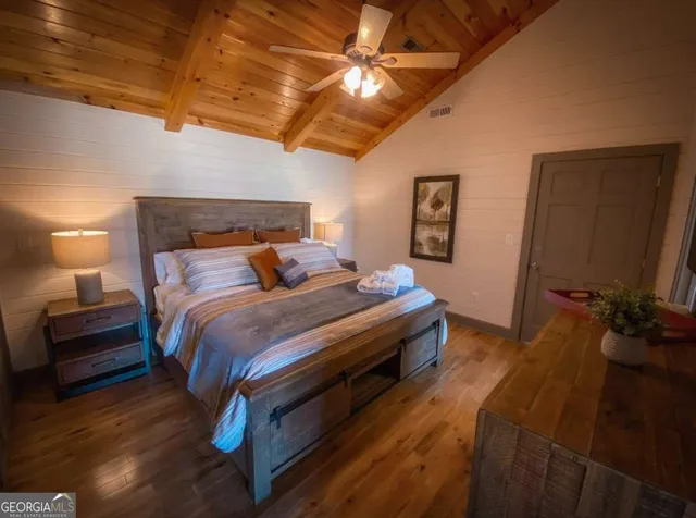 a bedroom with bed and wooden floor