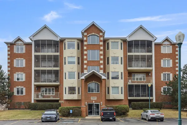 a front view of a residential apartment building with a yard