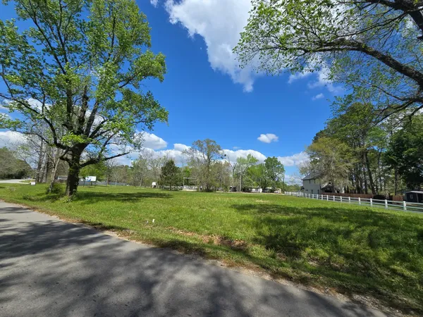 a view of a grassy field with trees around