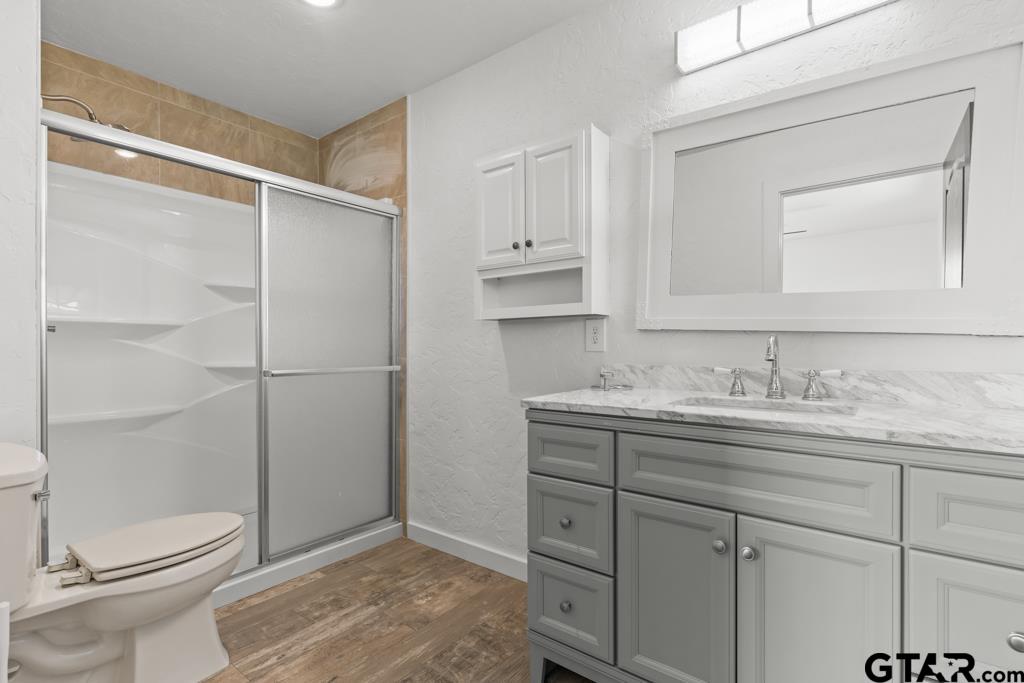 3400 Pony Road Gilmer, TX 75644 - Photo 16 of 46 a bathroom with a granite countertop sink toilet and shower