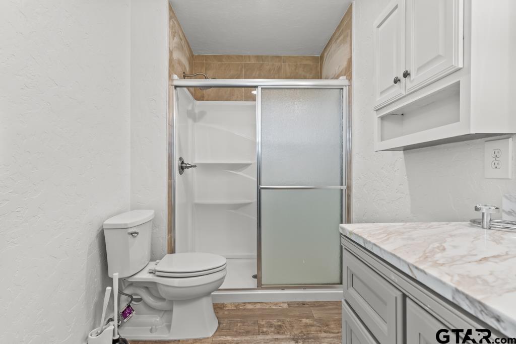 3400 Pony Road Gilmer, TX 75644 - Photo 17 of 46 a bathroom with a granite countertop toilet and a sink