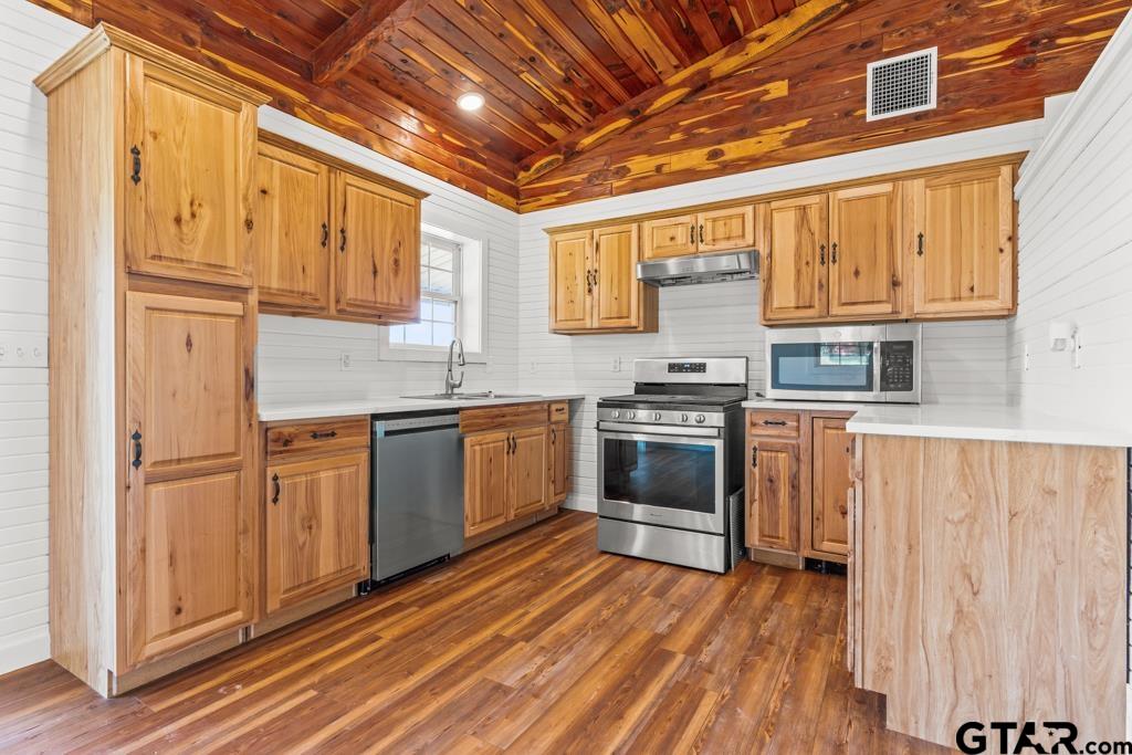 3400 Pony Road Gilmer, TX 75644 - Photo 7 of 46 a kitchen with stainless steel appliances granite countertop a stove a sink and a refrigerator
