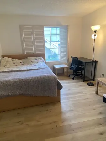 a bedroom with a bed and wooden floor