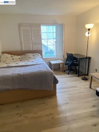 a bedroom with a bed and wooden floor