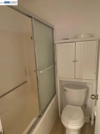 a white toilet sitting next to a shower