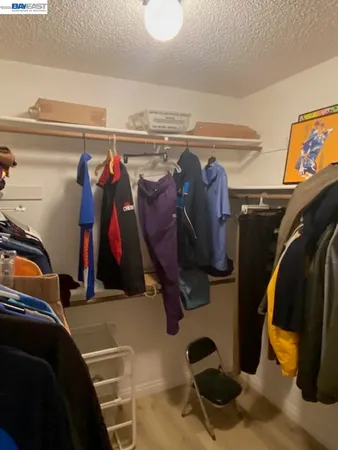 a view of walk in closet with clothes and shoes