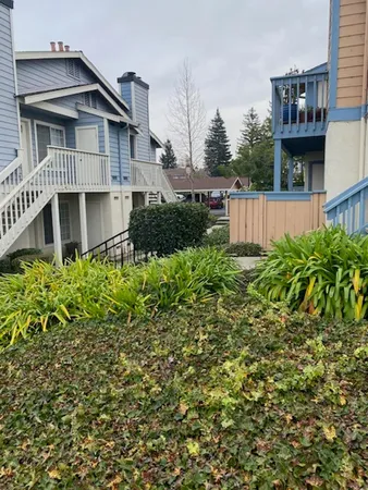 a view of a house with wooden fence and a bench in a yard
