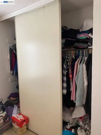 a view of walk in closet with clothes and shoes