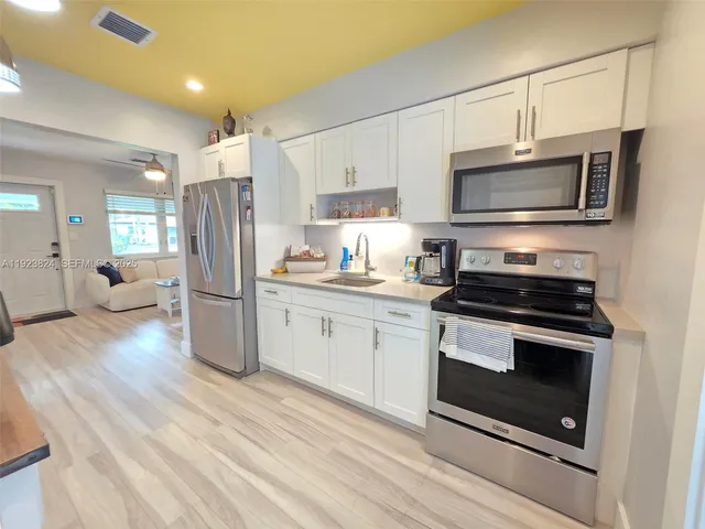 a kitchen with stainless steel appliances a stove a microwave sink and refrigerator