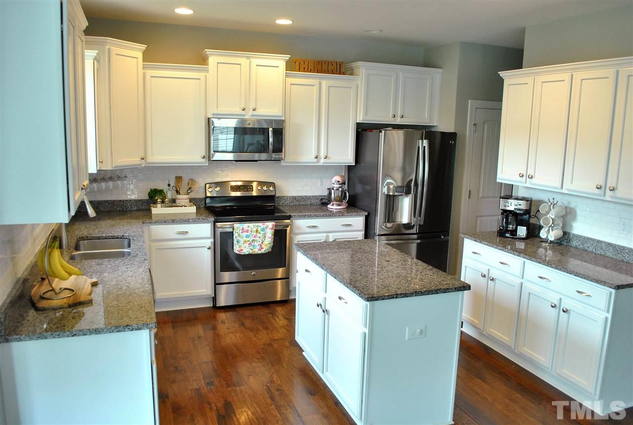100 Maraketch Court Raleigh, NC 27603 - Photo 2 of 22 a kitchen with stainless steel appliances granite countertop a refrigerator stove microwave and sink