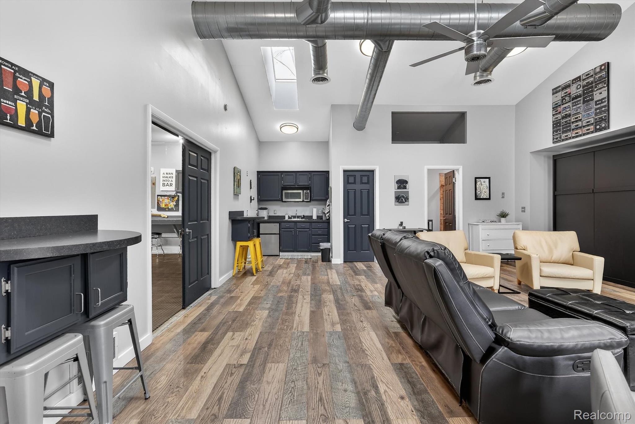 552 North McKinley Road Flushing, MI 48433 - Photo 63 of 98 Living room featuring lofted ceiling, dark wood-type flooring, a ceiling fan, and a skylight