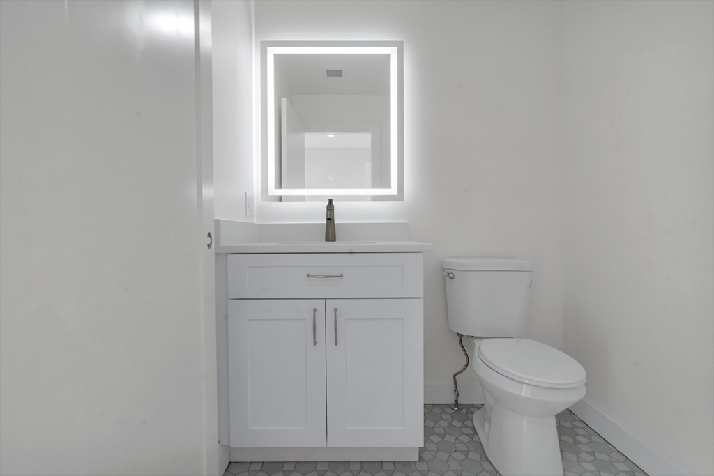 25 Columbine Road Rehoboth, MA 02769 - Photo 17 of 42 a bathroom with a toilet a sink a vanity and mirror