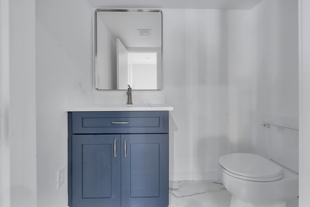 25 Columbine Road Rehoboth, MA 02769 - Photo 37 of 42 a bathroom with a toilet a sink and mirror