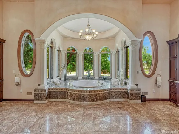 a view of a couches with a chandelier in big room