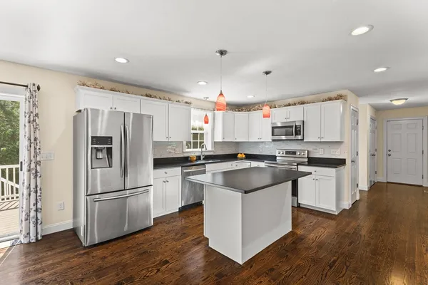 a kitchen with a refrigerator a sink and a microwave
