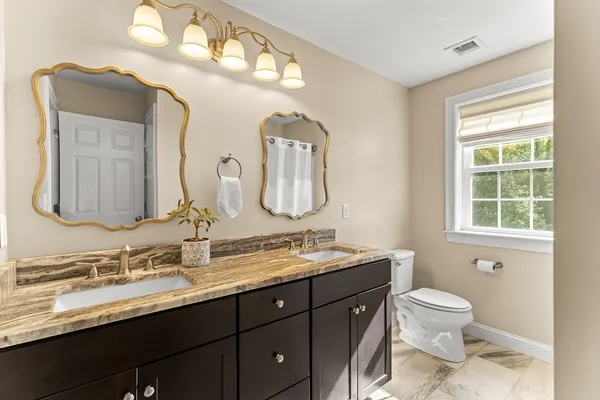 a bathroom with a double vanity sink and a mirror