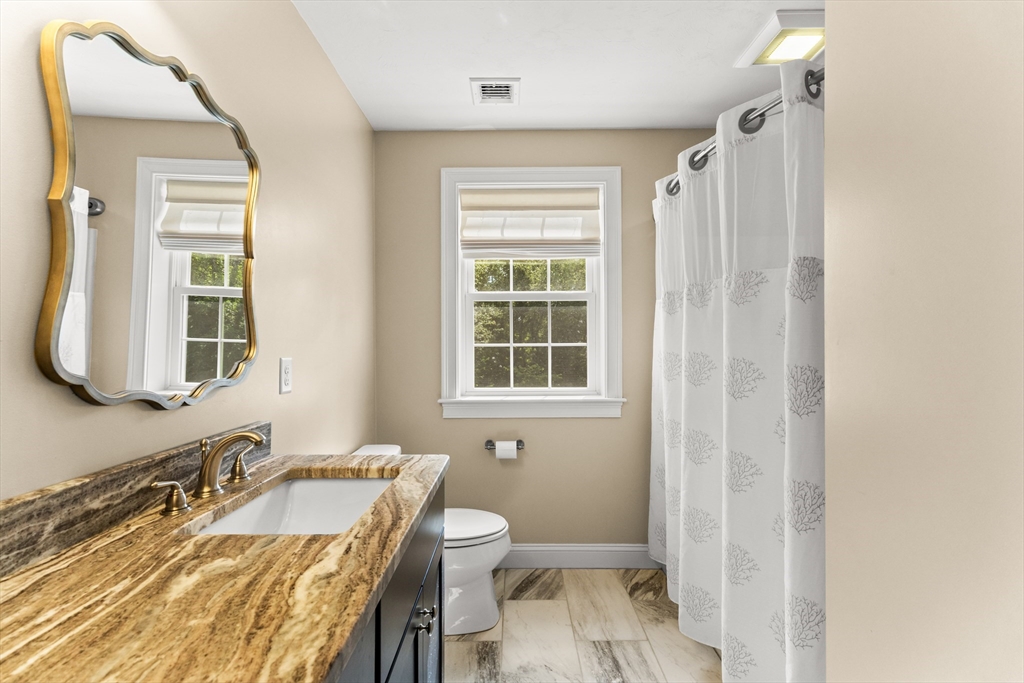 15 Carlton Street Raynham, MA 02767 - Photo 25 of 34 a bathroom with a granite countertop sink toilet a mirror and shower