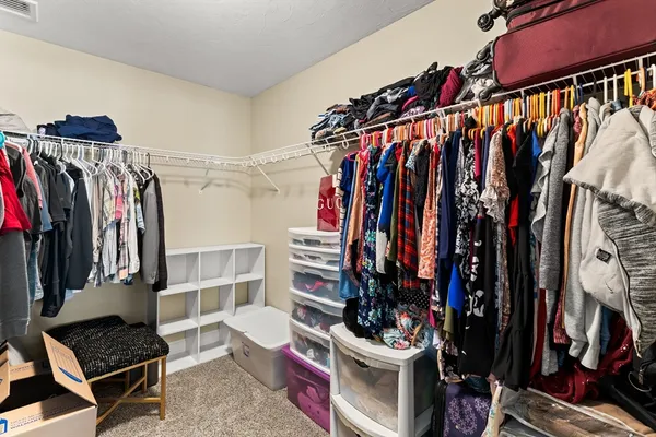 a view of walk in closet with clothes and shoes