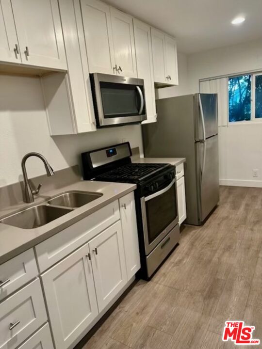 a kitchen with appliances a sink and cabinets