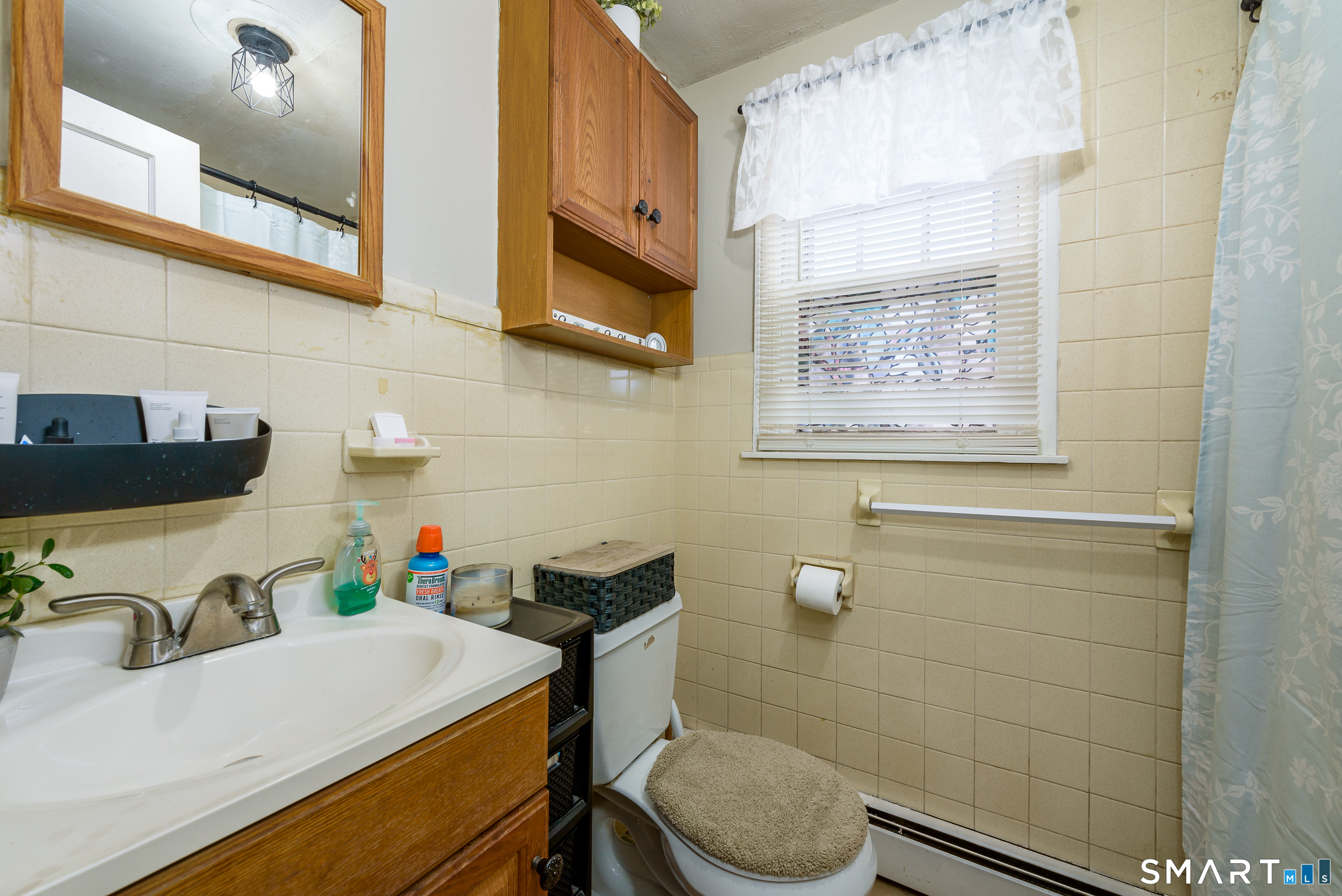 1035 North Worthy Street Windsor, CT 06095 - Photo 15 of 34 a bathroom with a sink a toilet and a mirror