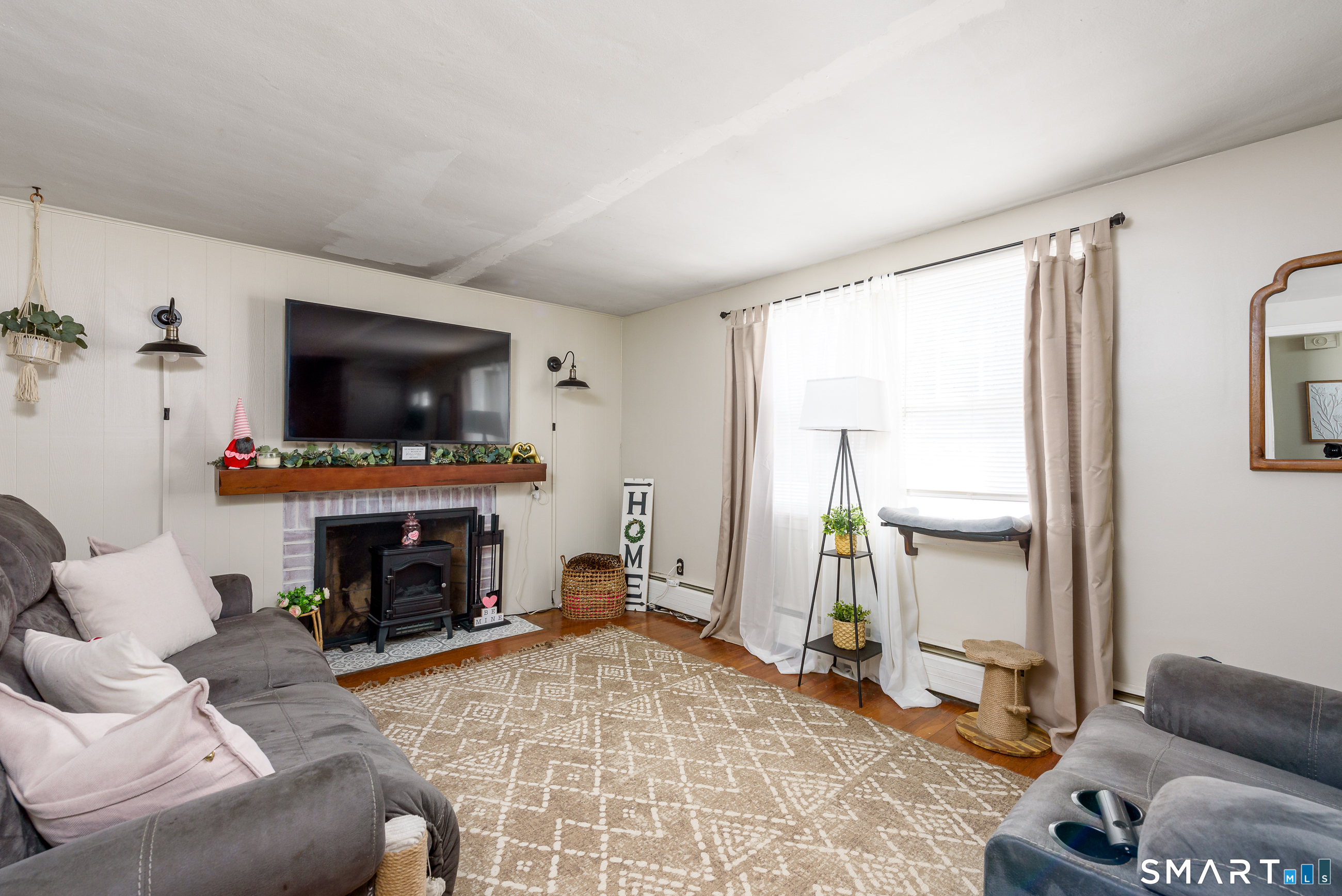 1035 North Worthy Street Windsor, CT 06095 - Photo 2 of 34 a living room with furniture a flat screen tv and a fireplace