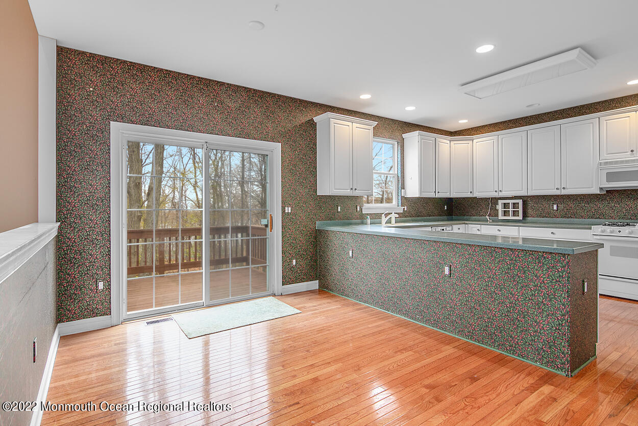 46 Glen Rock Road Cedar Grove, NJ 07009 - Photo 11 of 36 a kitchen with granite countertop a stove a sink a refrigerator white cabinets and wooden floor