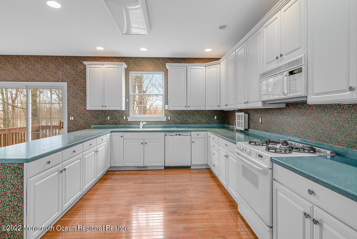 46 Glen Rock Road Cedar Grove, NJ 07009 - Photo 13 of 36 a large white kitchen with granite countertop a stove top oven a sink and dishwasher with white cabinets