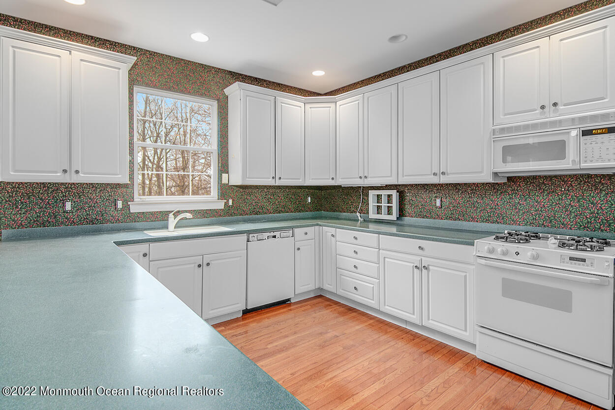 46 Glen Rock Road Cedar Grove, NJ 07009 - Photo 14 of 36 a kitchen with granite countertop white cabinets sink and white appliances