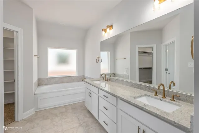 a bathroom with double vanity and a mirror