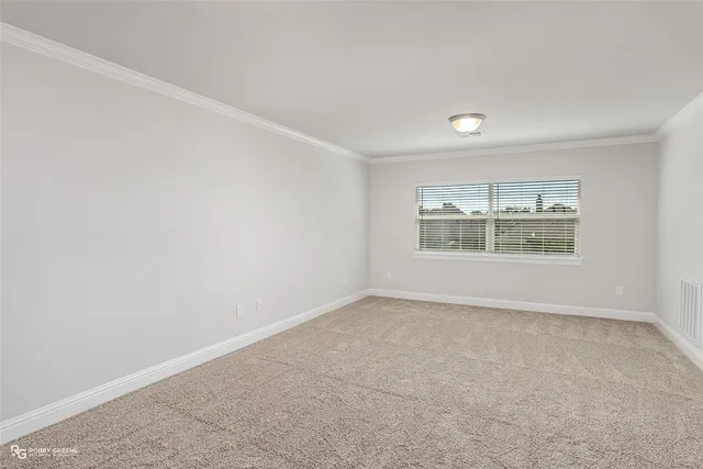an empty room with windows and fireplace