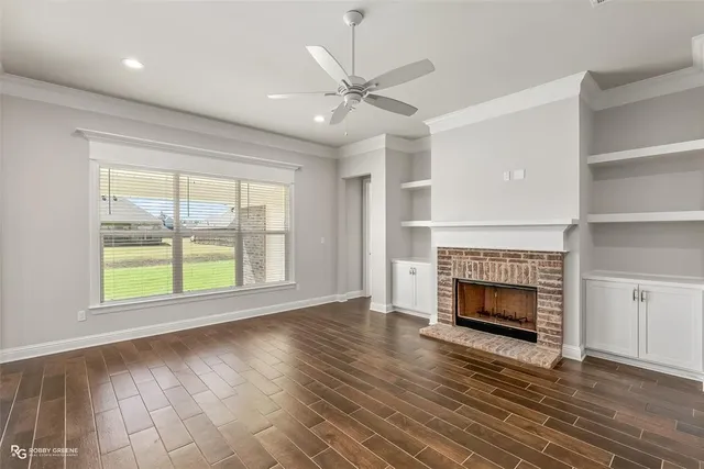 wooden floor fireplace and windows in an empty room
