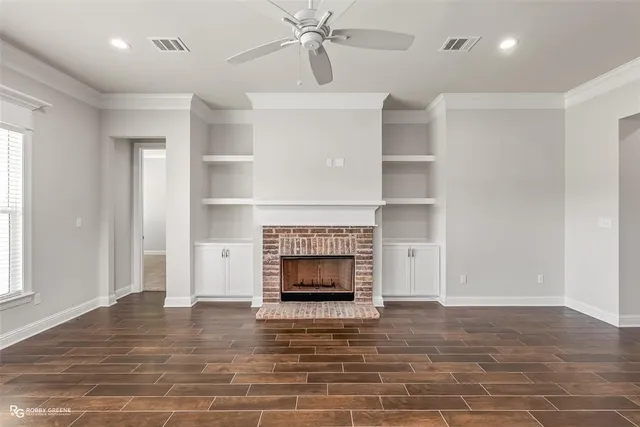 a view of a livingroom with a fireplace a chandelier and windows