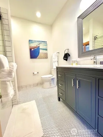 a bathroom with a sink a toilet and mirror