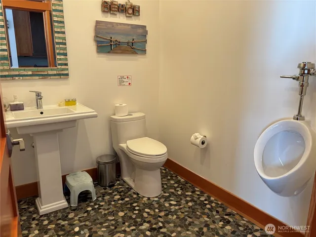 a bathroom with a toilet a sink and mirror