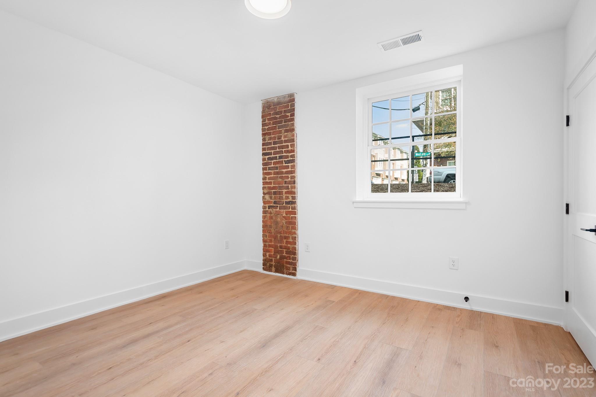 201 Grandin Road, Unit 14 Charlotte, NC 28208 - Photo 12 of 15 an empty room with wooden floor and windows