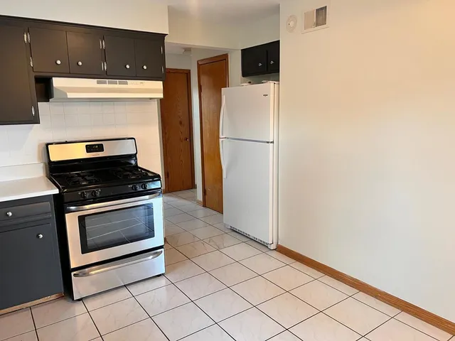a kitchen with a refrigerator and a stove