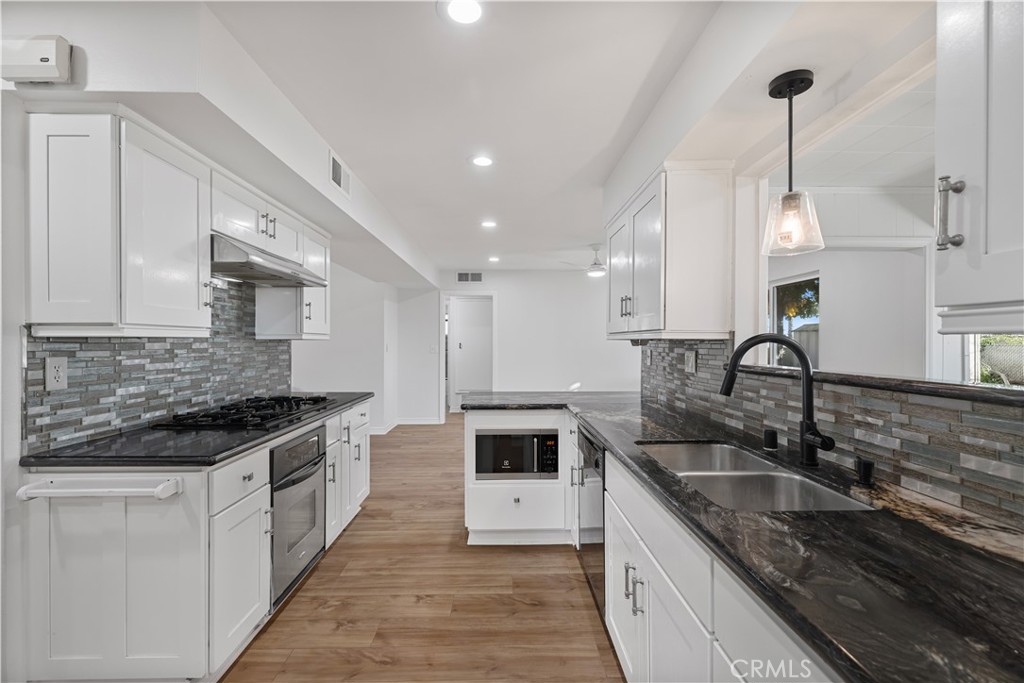 27345 El Rancho Road Sun City, CA 92586 - Photo 1 of 1 a kitchen with granite countertop a sink and stove top oven