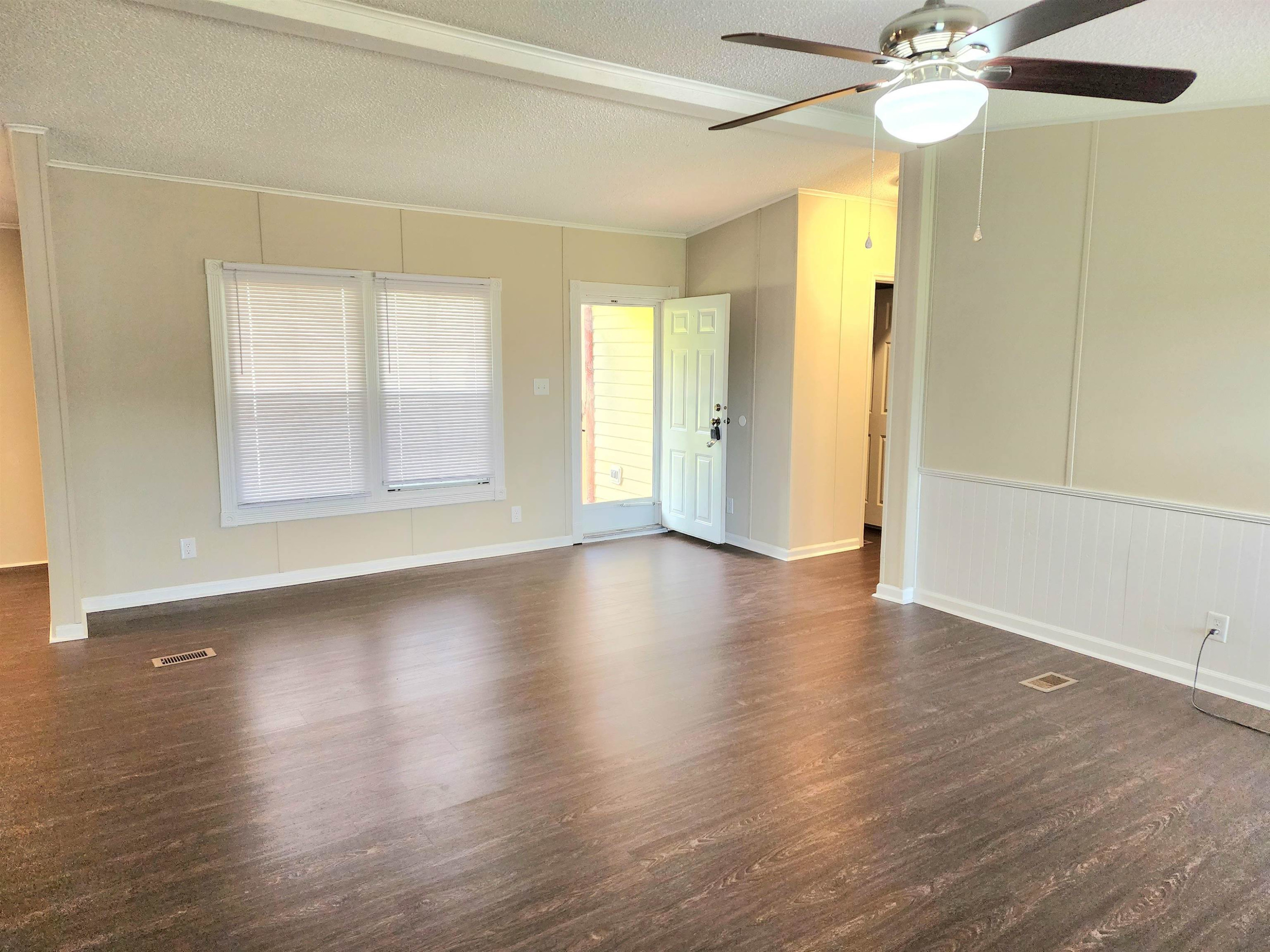 8333 Creek Road Willow Spring, NC 27592 - Photo 12 of 58 a view of a livingroom with wooden floor and a ceiling fan